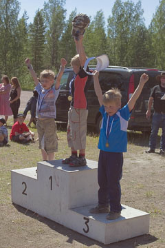 6-7 -vuotiaiden poikien 60m juoksun kolme parasta Tomi Hämäläinen, Jonne Närhi ja Niklas Ritalahti tuulettavat palkintopallilla.
